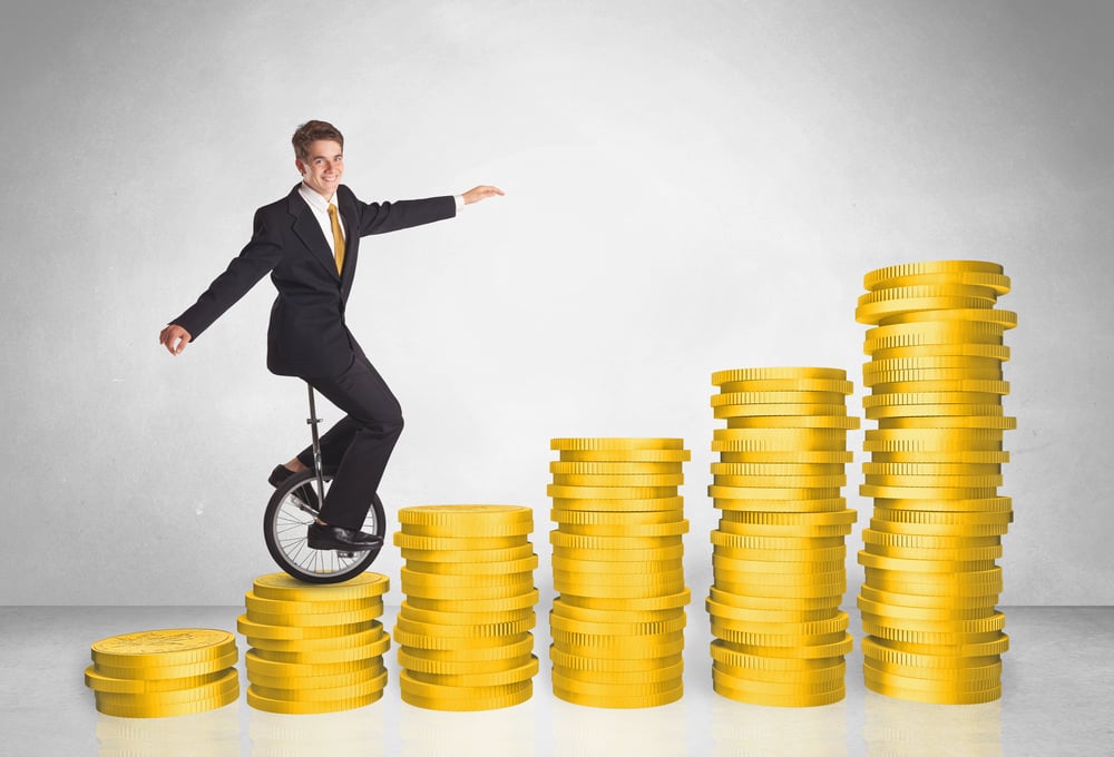 Business man riding monocycle up on coin graph concept on background