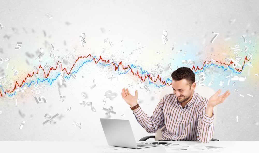 Business man sitting at table with stock market graph 3d letters